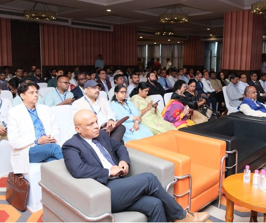  Audience in a conference room with many attendees sitting in rows, focused on an event.